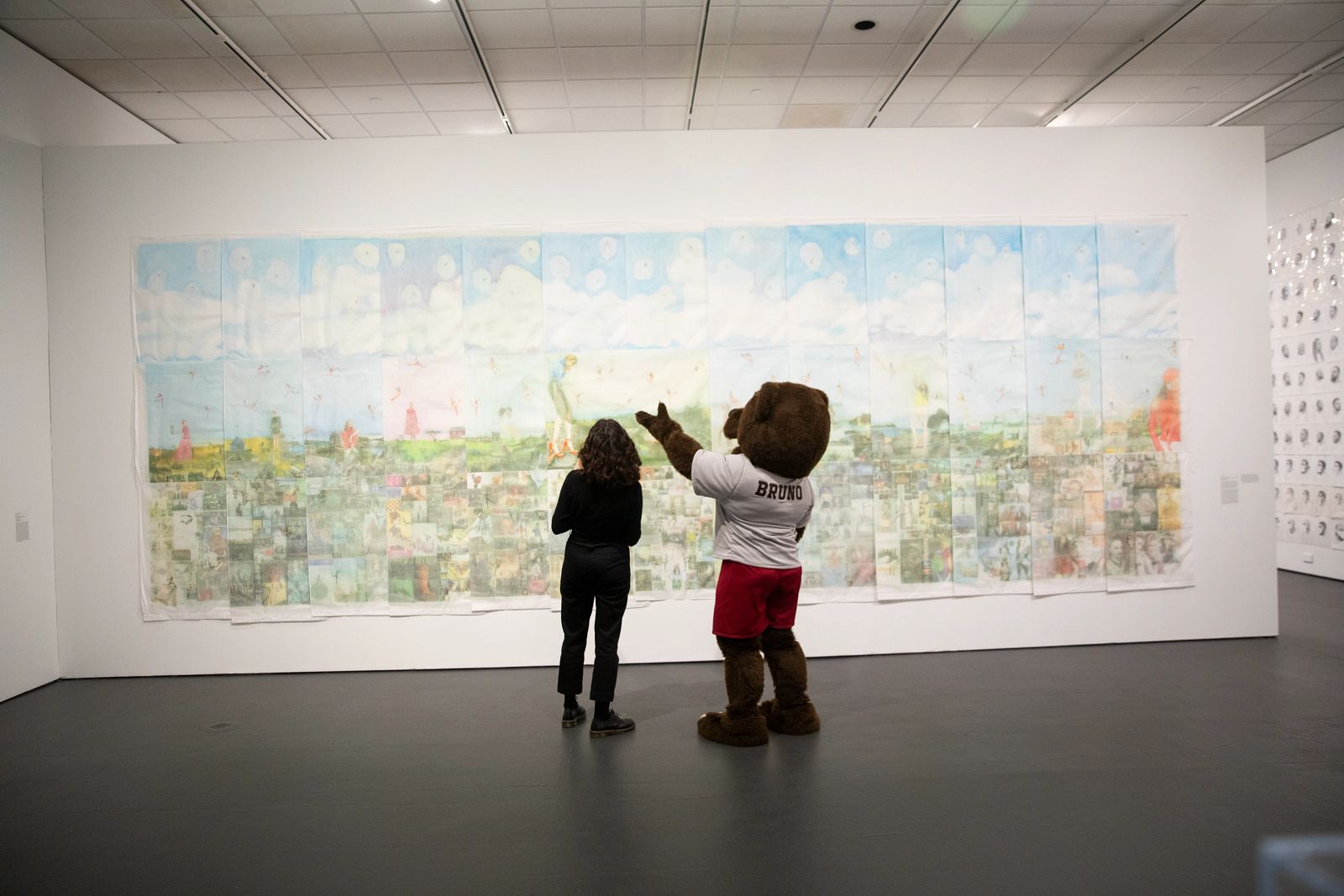 Bruno the bear mascot pointing at a mural